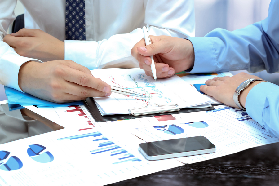 Business Colleagues Working Together And Analyzing Financial Fig